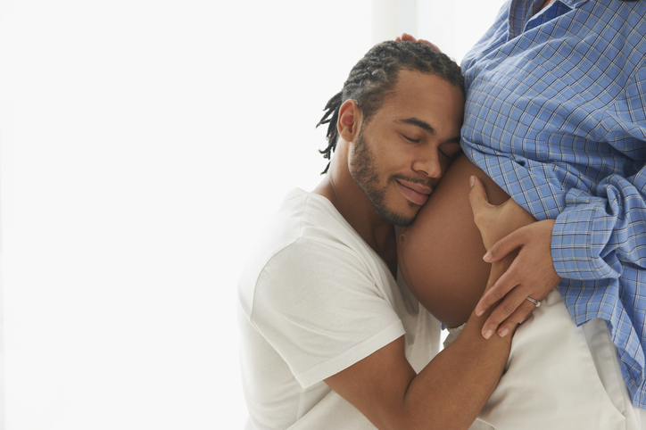 Husband hugging pregnant wife's stomach