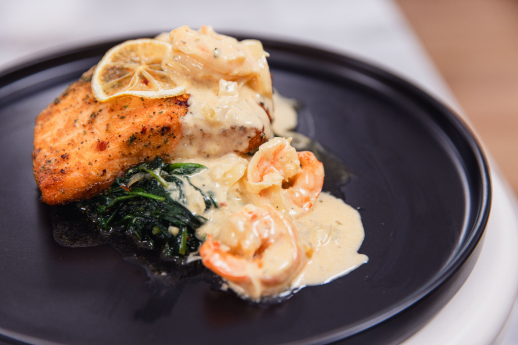 Baked Salmon with Shrimp Alfredo Sauce over Sautéed Spinach