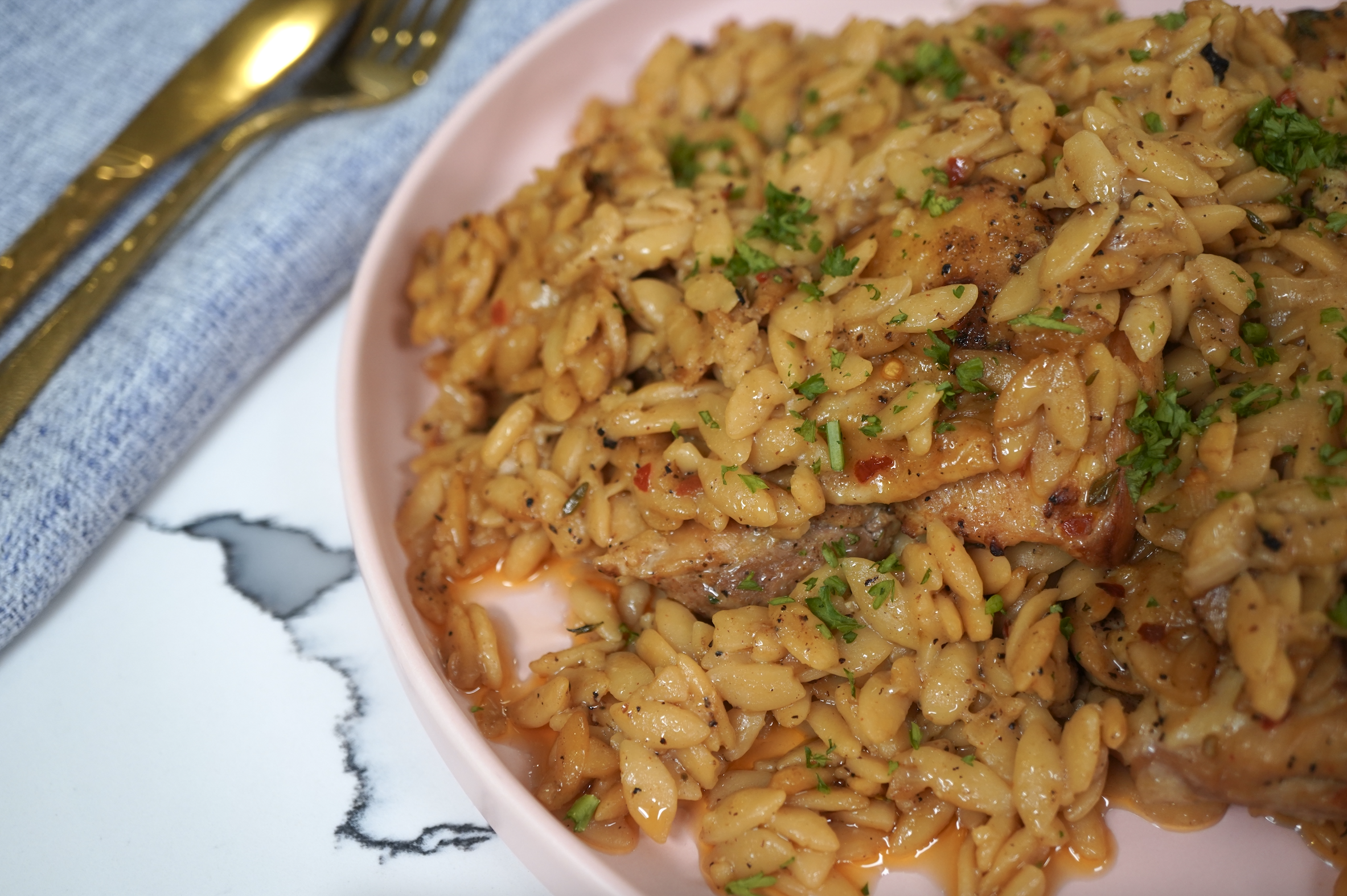 A plate of savory fried rice with vegetables and seasoned meat, garnished with fresh herbs.